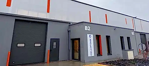 graues Firmengebäude mit Rolltor und Fenster